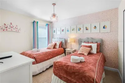 a bedroom with two beds and a sink in it at Luxury Pool Home Near Disney Resort Amenities in Kissimmee