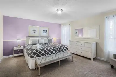 a bedroom with a bed and a dresser at Luxury Pool Home Near Disney Resort Amenities in Kissimmee