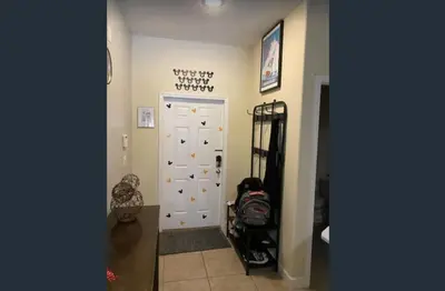 a hallway with a white door with a stroller next to it at Disney & Resort Fun Private Pool Renovated in Kissimmee