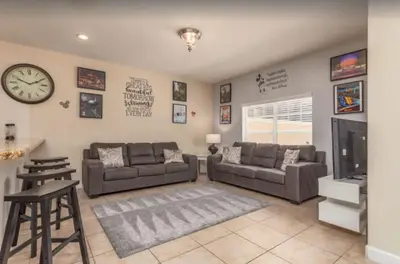a living room with two couches and a clock on the wall at Disney & Resort Fun Private Pool Renovated in Kissimmee