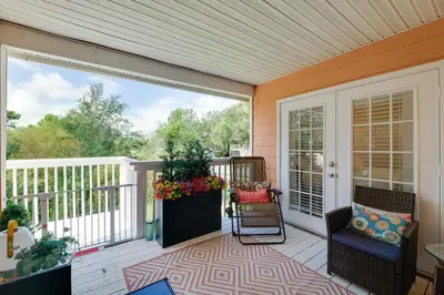 a screened in porch with a rocking chair and aolicy at 5 Mi to WDW Resort-Style Condo with Pool Access in Kissimmee