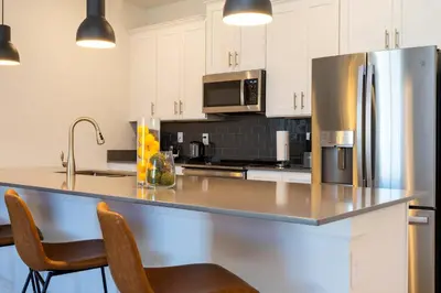 a kitchen with a stainless steel refrigerator and cabinets at Stylish & Fun Retreat Pool Themed Rooms in Kissimmee
