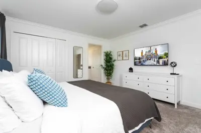 a white bedroom with a bed and a dresser at Stylish & Fun Retreat Pool Themed Rooms in Kissimmee