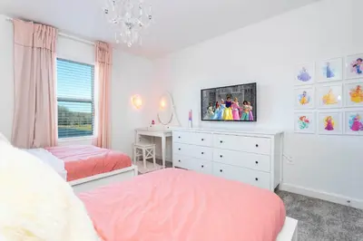a bedroom with two beds and a tv on the wall at Stylish & Fun Retreat Pool Themed Rooms in Kissimmee