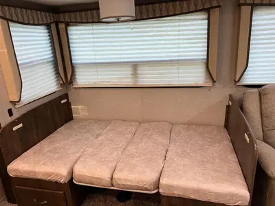 a small bed in a room with two windows at Beautiful RV 15 Min to Downtown Orlando in Orlando