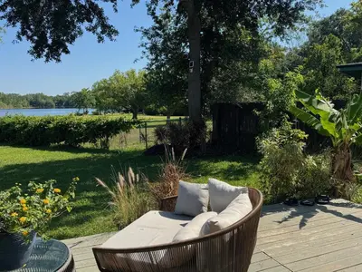 a wicker couch sitting on a deck with a view of the water at Chic & Stylish 3BR-2BA Nature Lovers Home in Orlando