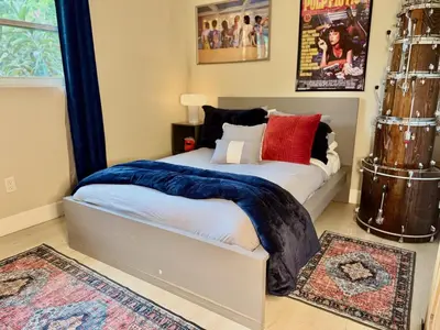 a bedroom with a bed with blue and red pillows at Chic & Stylish 3BR-2BA Nature Lovers Home in Orlando