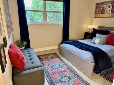 a bedroom with a bed and a couch and a window at Chic & Stylish 3BR-2BA Nature Lovers Home in Orlando