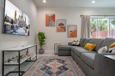 a living room with a gray couch and a rug at New Vacay Home 5BD 5BA - 5 miles to Disney in Orlando