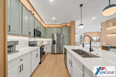 a kitchen with white cabinets and a stainless steel refrigerator at The Epic New Jersey Vista Cay in Orlando