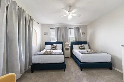 a bedroom with two beds and a ceiling fan at Serenity in the sun in Kissimmee