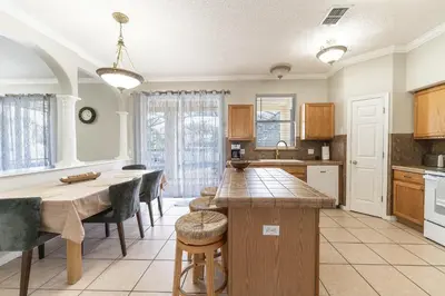 a kitchen with a wooden table and a dining room at Serenity in the sun in Kissimmee