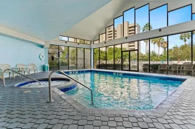 a swimming pool in a building with a large window at Apartamento Moderno 2 Quartos no Enclave in Orlando