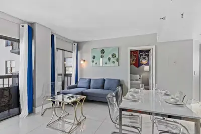 a living room with a blue couch and a table at Apartamento Moderno 2 Quartos no Enclave in Orlando