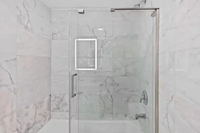 a shower with a glass door in a bathroom at Apartamento Moderno 2 Quartos no Enclave in Orlando
