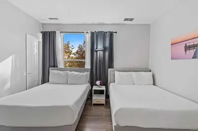 two beds in a room with a window at Townhouse 3 suítes no Vista Cay Resort in Orlando