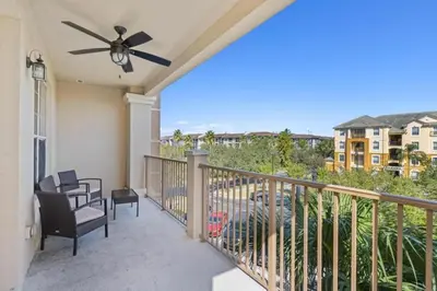 a porch with a ceiling fan and chairs on a balcony at Apartamento moderno 3 quartos no Vista Cay in Orlando