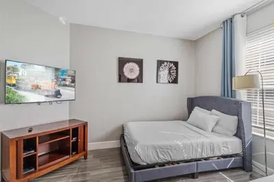 a living room with a chair and a flat screen tv at Apartamento moderno 3 quartos no Vista Cay in Orlando