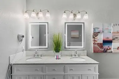 a bathroom with two sinks and two mirrors at Apartamento moderno 3 quartos no Vista Cay in Orlando