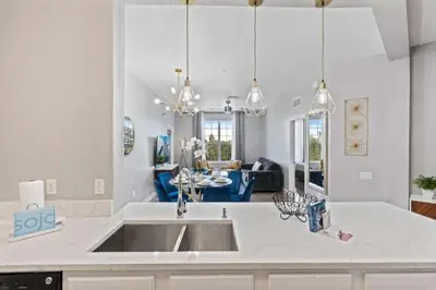 a kitchen with a sink and a living room at Moderno apê 3 quartos no Vista Cay – Perto Disney in Orlando