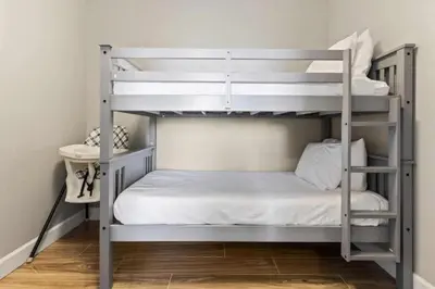 a gray bunk bed with a white bedsheet at Moderno apê 3 quartos no Vista Cay – Perto Disney in Orlando