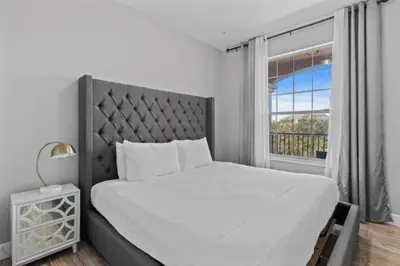 a white bedroom with a large bed and a window at Moderno apê 3 quartos no Vista Cay – Perto Disney in Orlando