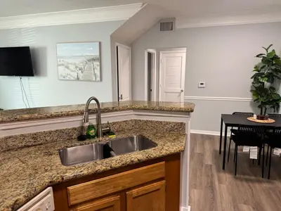 a kitchen with a stainless steel sink and a table at Bellavue Getaway in Kissimmee
