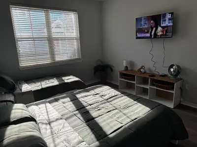 a bedroom with two beds and a tv on the wall at Bellavue Getaway in Kissimmee