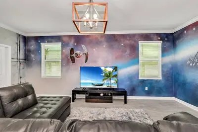 a living room with a couch and a flat screen tv at Last Minute Disney Private Pool Hot Tub Game Room Themed Bedrooms. Book Now SLR551 in Kissimmee