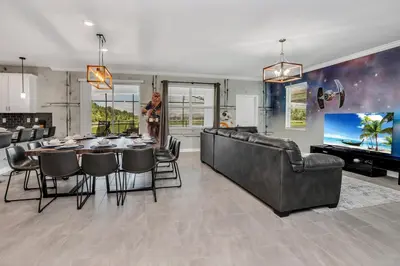 a dining room and living room with a table and chairs at Last Minute Disney Private Pool Hot Tub Game Room Themed Bedrooms. Book Now SLR551 in Kissimmee