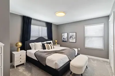 a bedroom with a bed and a chair in it at Last Minute Disney Luxury Townhouse with Private Pool. Book Now SLR557 in Kissimmee