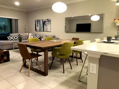 a kitchen and living room with a table and chairs at NEW Home 3 Bedrooms Water View Disney Universal in Kissimmee