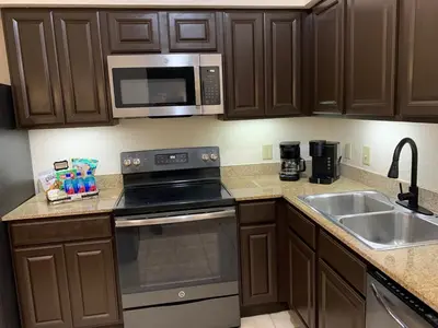 a kitchen with a stove and a sink and a microwave at Near Orlando Convention center and all Park's in Orlando