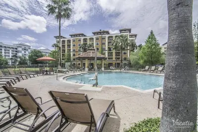 a resort with a pool and chairs and a building at Near Orlando Convention center and all Park's in Orlando