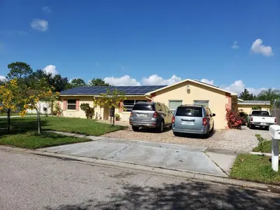 a house with two cars parked in a driveway at Paradise Apartment in Orlando