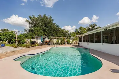 a swimming pool in front of a house at Paradise Apartment in Orlando