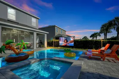 a house with a swimming pool and a tv at Family Escape | Moana Vibes | Pool + Games in Orlando