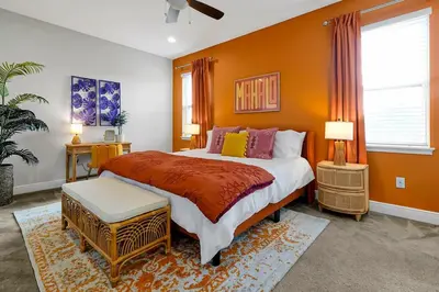 a bedroom with a large bed with orange walls at Family Escape | Moana Vibes | Pool + Games in Orlando