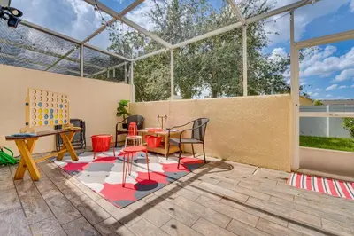 a glass house with a table and chairs in a patio at 10 Mi to Disney World Townhome with Community Pool! in Kissimmee