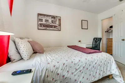 a bedroom with a bed and a table with a remote control at 10 Mi to Disney World Townhome with Community Pool! in Kissimmee