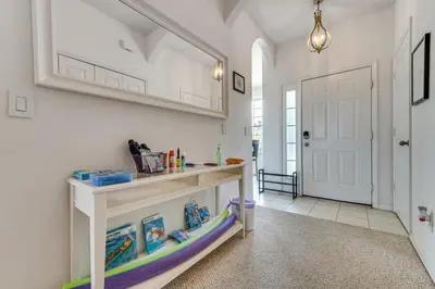 a white hallway with a shelf and a white door at 10 Mi to Disney World Townhome with Community Pool! in Kissimmee