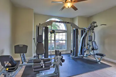 a gym with several tread machines and a ceiling fan at 10 Mi to Disney World Townhome with Community Pool! in Kissimmee