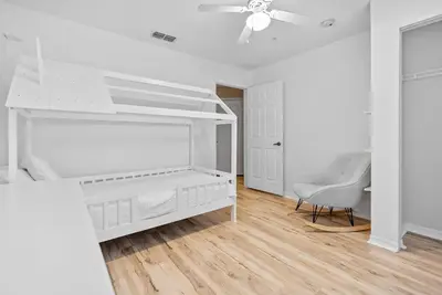 a white bedroom with a bed and a ceiling fan at Cozy Themed 04 bedrooms - Close to Disney in Kissimmee
