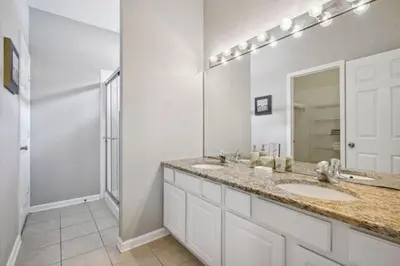 a bathroom with two sinks and a large mirror at Paradise Villa in Orlando