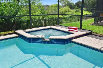 a swimming pool with a bench in the middle at Paradise Villa in Orlando