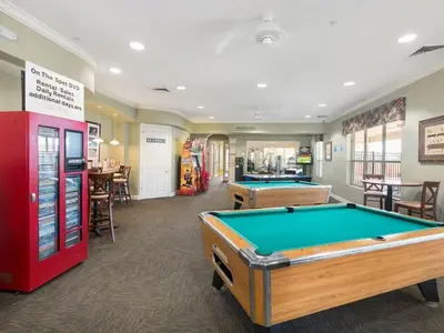 a billiard room with two pool tables and a red machine at Paradise Villa in Orlando