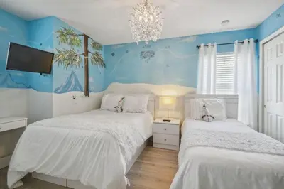 two beds in a bedroom with blue walls at Paradise Villa in Orlando