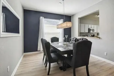a dining room with a black table and chairs at Paradise Villa in Orlando