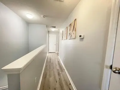 a hallway with white walls and a wooden floor at 4 Bed Private Yard-Pool Home in Kissimmee
