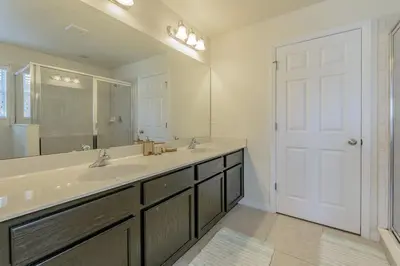 a bathroom with a sink and a large mirror at 4 Bed Private Yard-Pool Home in Kissimmee